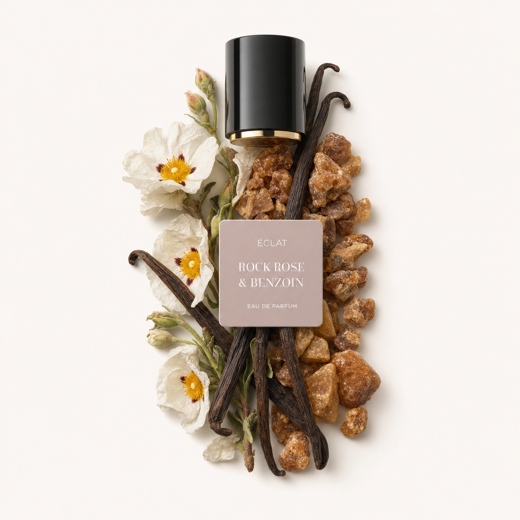 Un arrangiamento di baccelli di vaniglia, fiori di cisto e resina di benzoino circonda un tappo nero con bordo dorato e etichetta ÉCLAT Rock Rose & Benzoin.