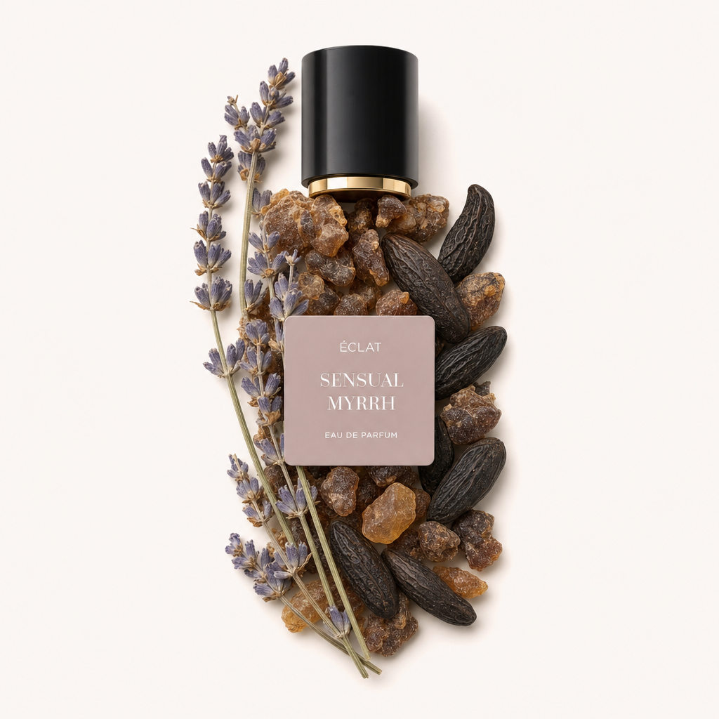 Una composizione di rametti di lavanda, resina di mirra e fave tonka avvolge un tappo nero con bordo dorato e un'etichetta ÉCLAT Sensual Myrrh.