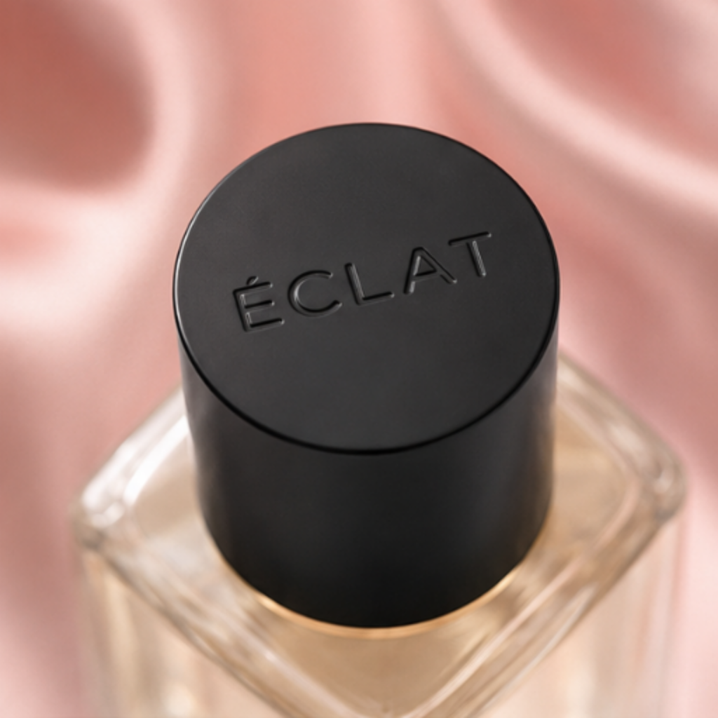 ÉCLAT Silk & Cashmere in un flacone di vetro sfaccettato con tappo nero opaco su sfondo di seta rosa.