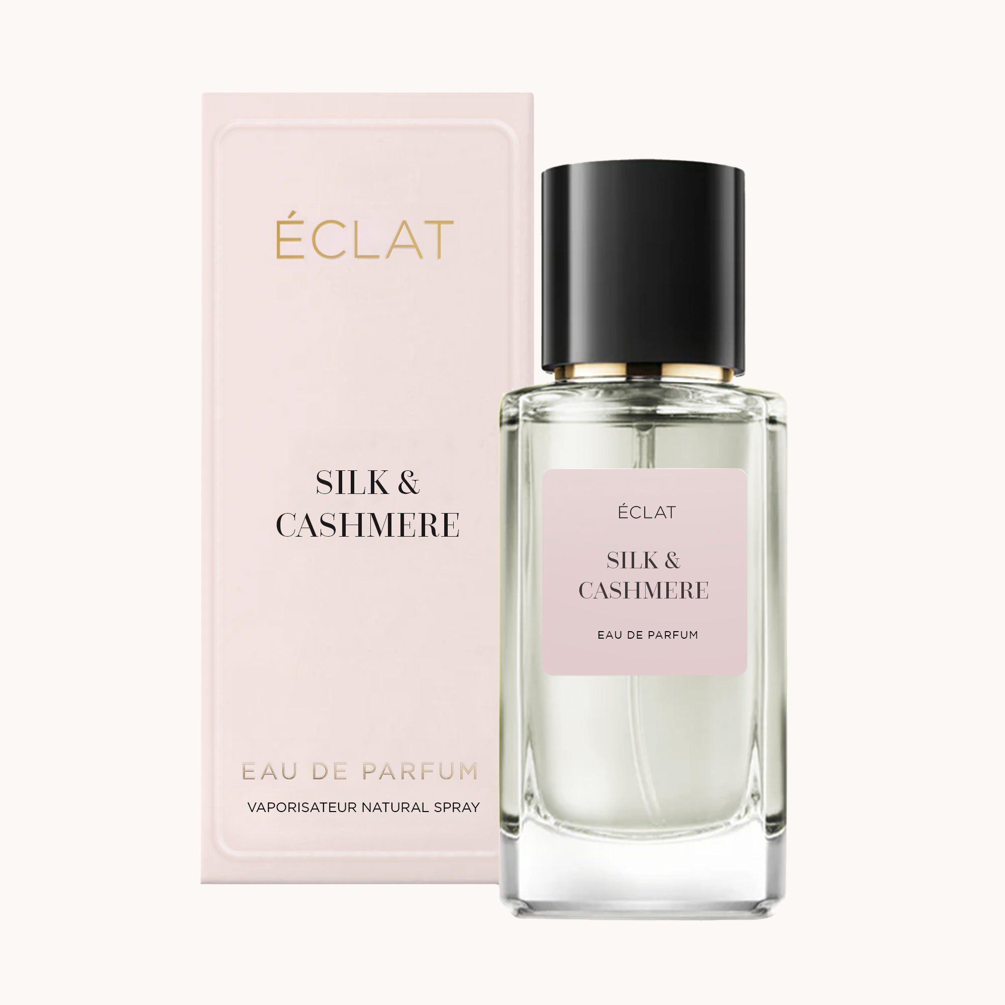 Profumo ÉCLAT Silk & Cashmere con flacone in vetro sfaccettato e tappo nero lucido accanto alla sua elegante scatola pastello.