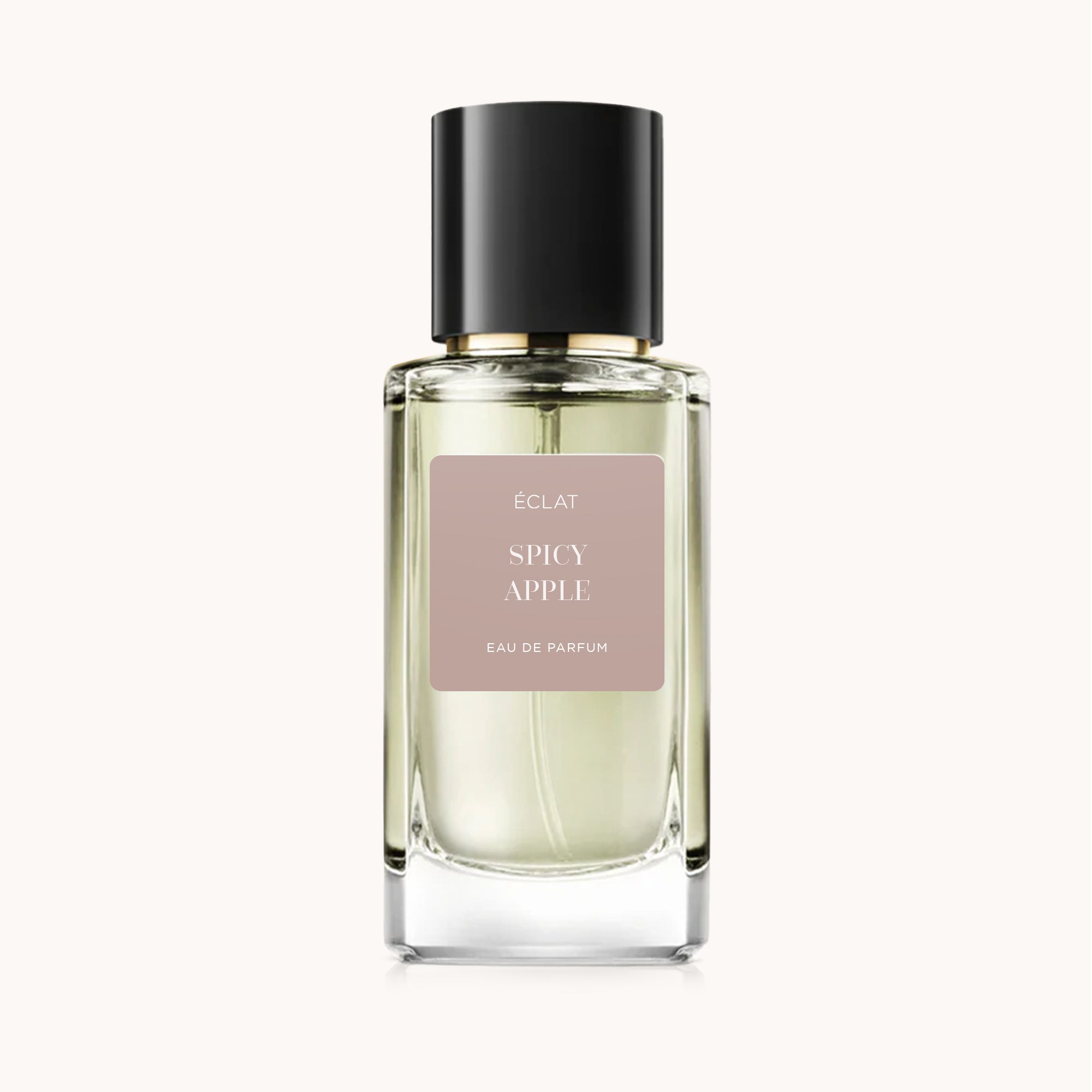 Flacone di vetro sfaccettato di ÉCLAT Spicy Apple con tappo nero elegante, etichetta opaca su sfondo beige chiaro.