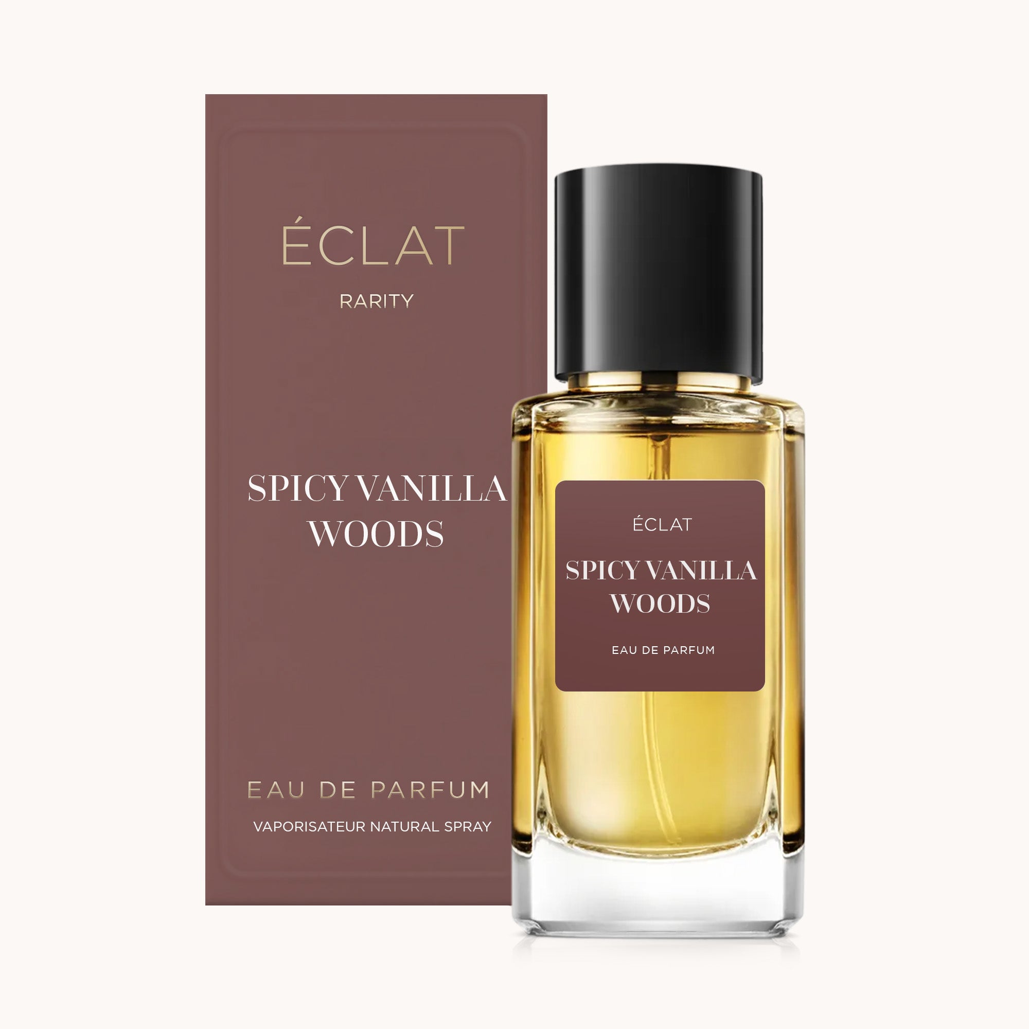 Flacone in vetro sfaccettato di ÉCLAT Spicy Vanilla Woods con tappo nero, accanto a una scatola marrone abbinata.