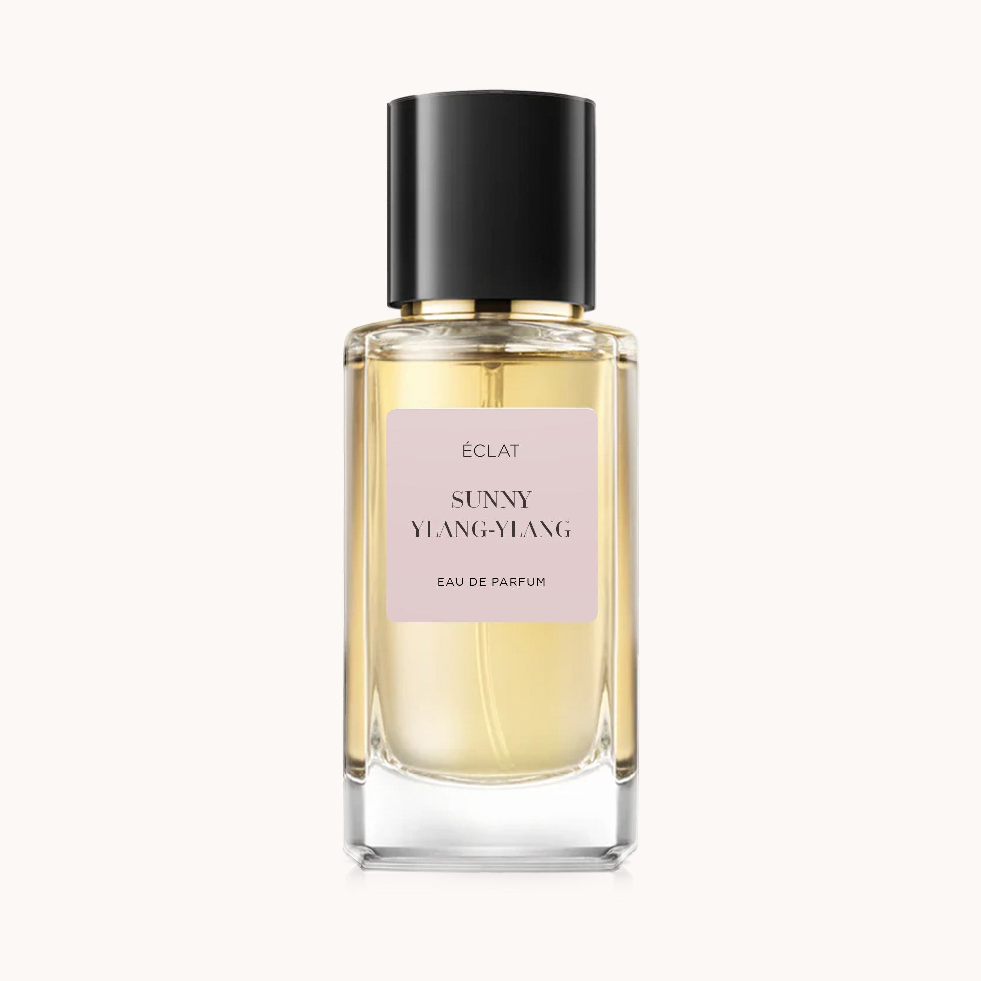 Flacone in vetro sfaccettato di ÉCLAT Sunny Ylang-Ylang con etichetta beige e tappo nero lucido.
