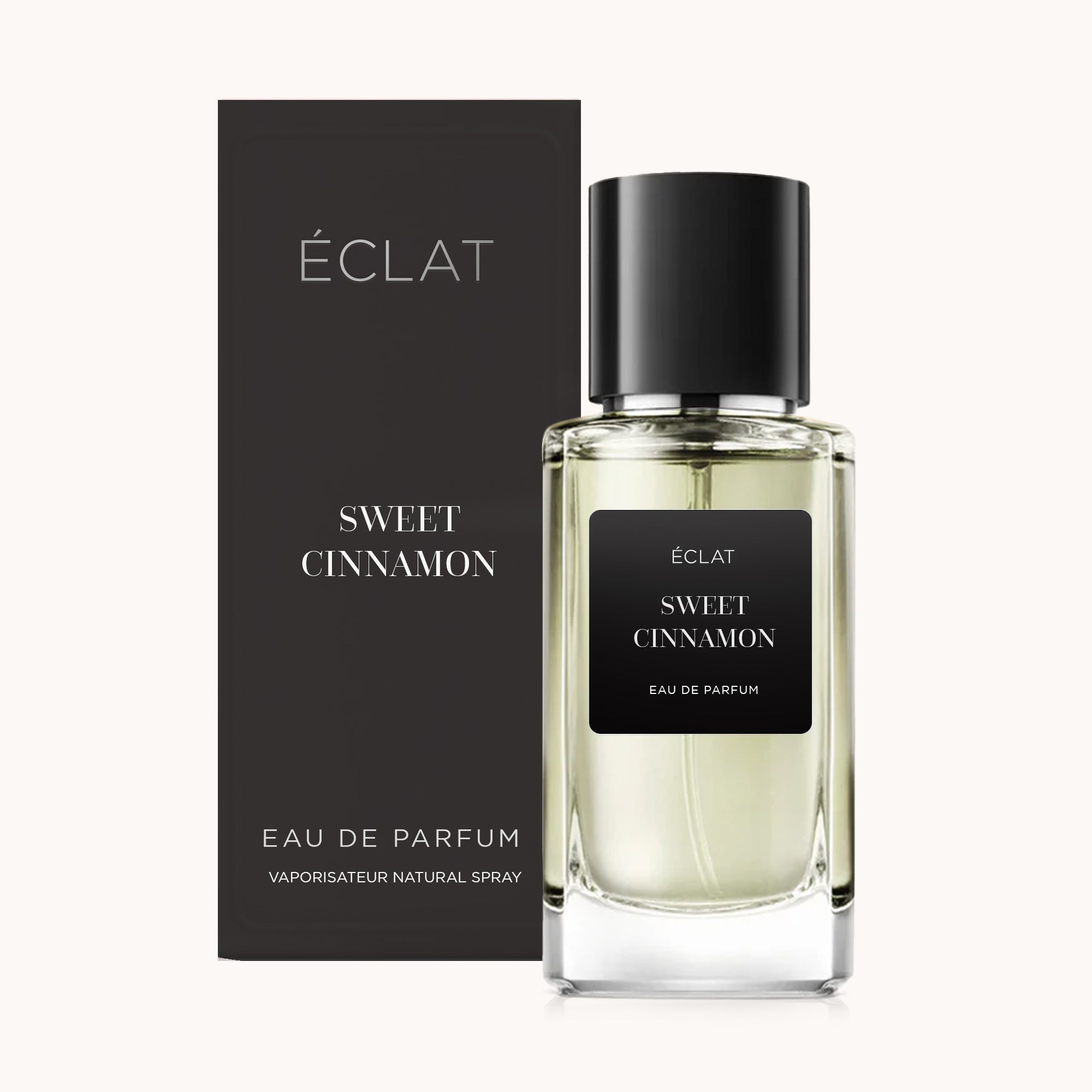 Flacone in vetro di ÉCLAT Sweet Cinnamon con etichetta nera e scatola nera abbinata sullo sfondo.