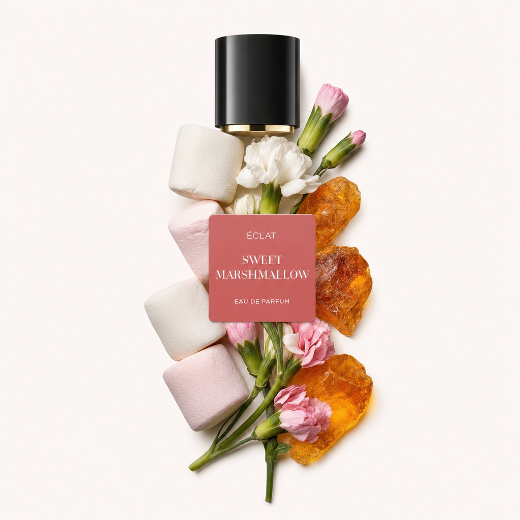 Una composizione elegante di marshmallow, fiori bianchi e rosa e cristalli di zucchero arancioni circonda un tappo nero con etichetta ÉCLAT Sweet Marshmallow.