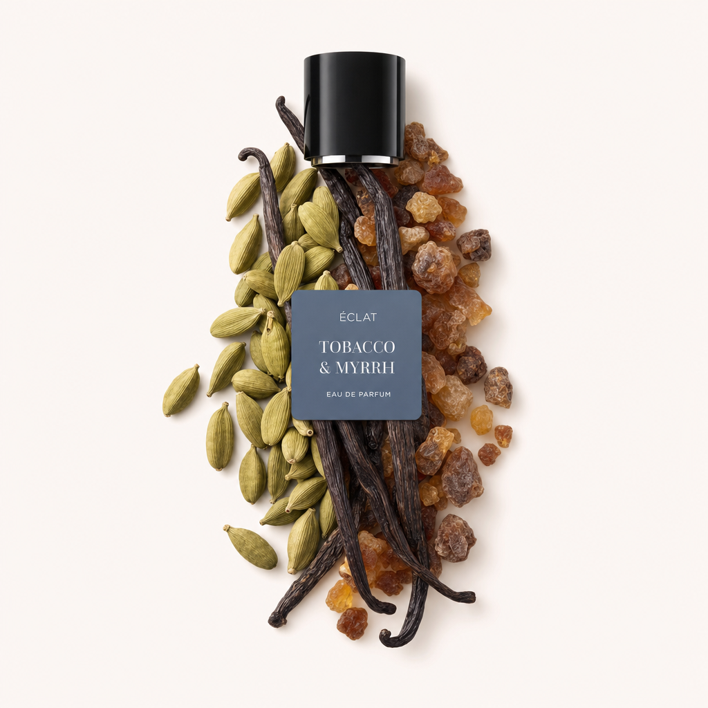 Un arrangiamento di baccelli di cardamomo, bacche di vaniglia e resina di mirra con un tappo nero ÉCLAT etichettato 'Tobacco & Myrrh' sopra.