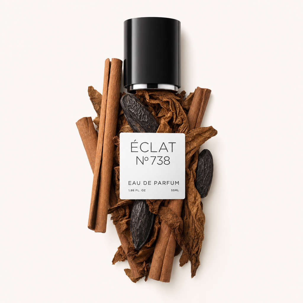 Un tappo nero con etichetta ÉCLAT Tonka Bean & Cinnamon è posizionato su un insieme di bastoncini di cannella e fave tonka.