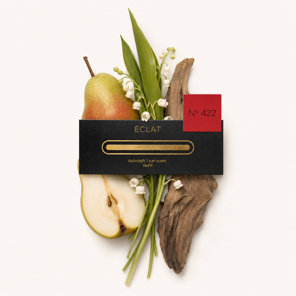 Una composizione di pera a fette, fiori di mughetto, foglie verdi e legno alla deriva, completata dal tappo nero di ÉCLAT con etichetta rossa.
