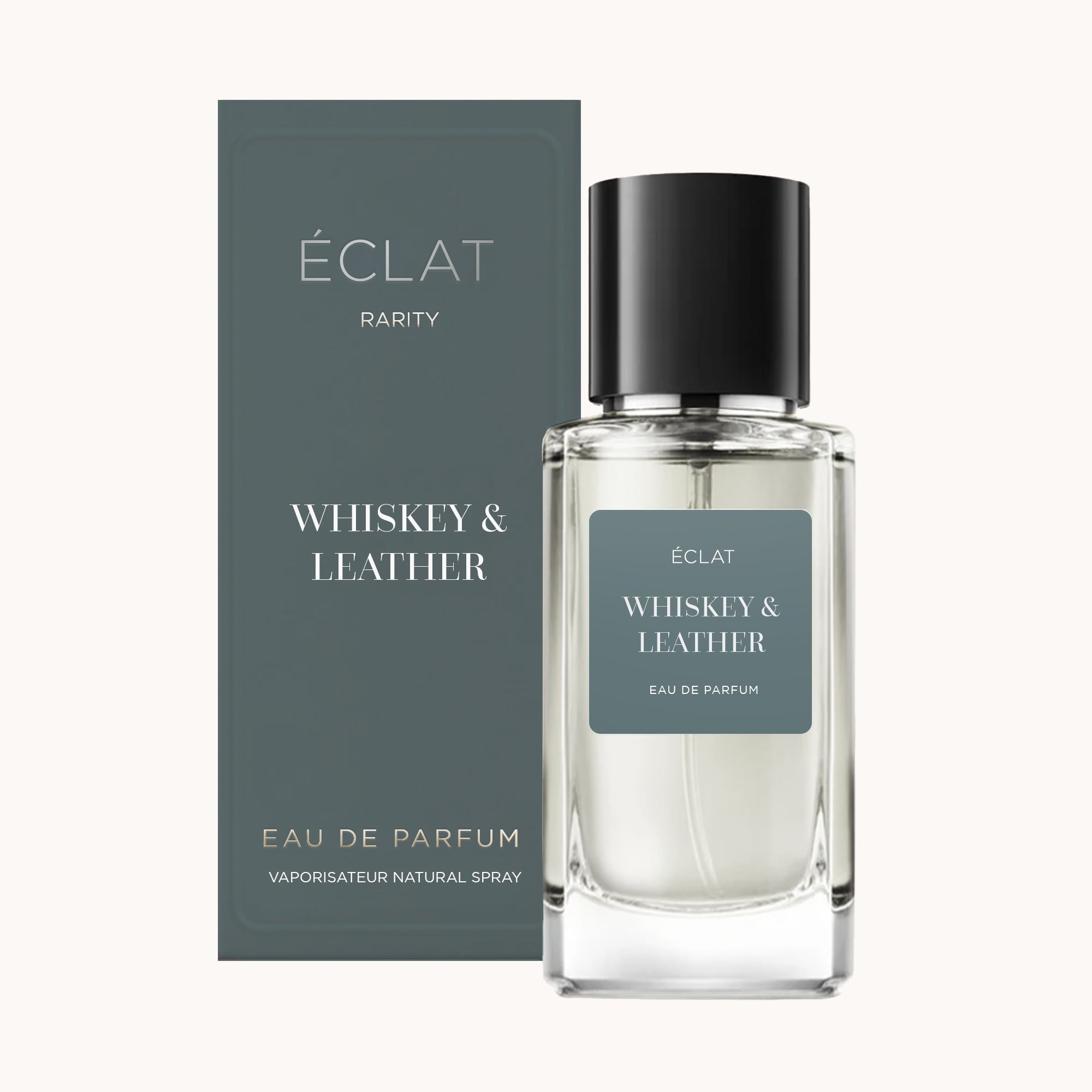 Fragranza ÉCLAT Whiskey & Leather in un flacone di vetro trasparente con tappo nero, accompagnata dalla sua elegante confezione abbinata in blu tenue.